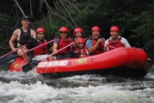 Happy family white water rafting on the Pigeon River, one of the most popular Gatlinburg sports.