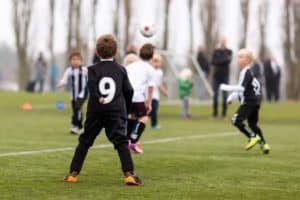 Boys playing Smoky Mountain soccer outdoors surrounded by trees