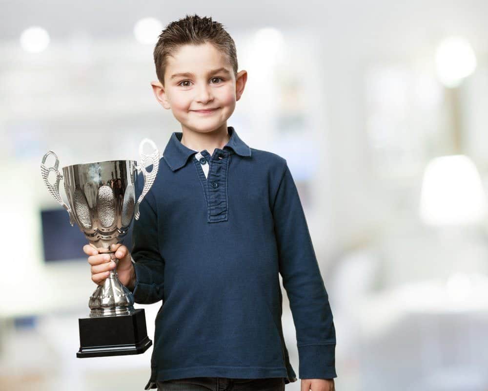 kid with trophy from awards ceremony