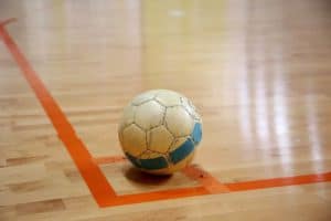 A futsal ball in the corner of a court.