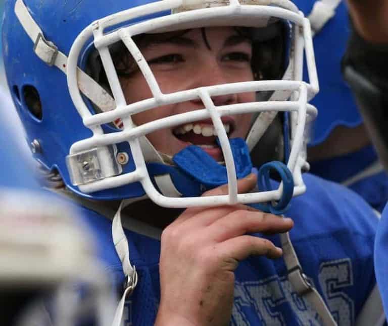 Boy smiling while removing his mouth guard at a Gatlinburg football game.