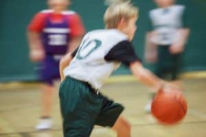 A blurred photo of kids playing basketball.