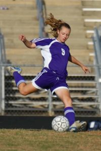 A young woman playing soccer.