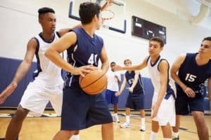 Young men playing in a high school basketball game.