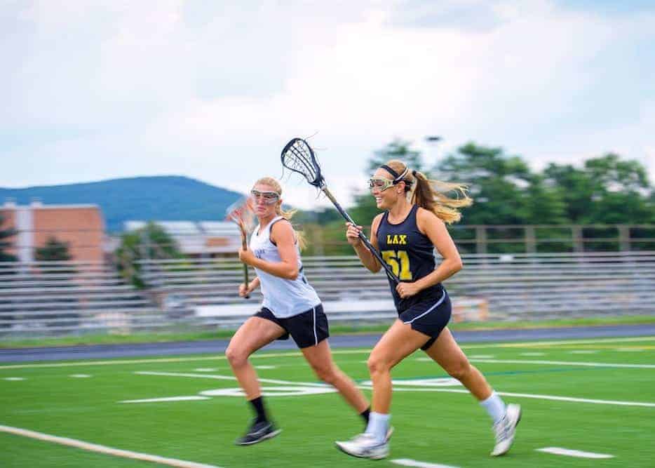 Young women playing lacrosse.