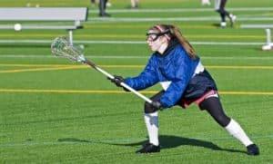 A young woman playing lacrosse.