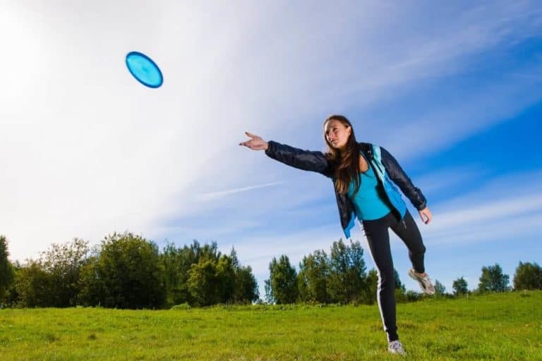 A young woman throwing a frisbee