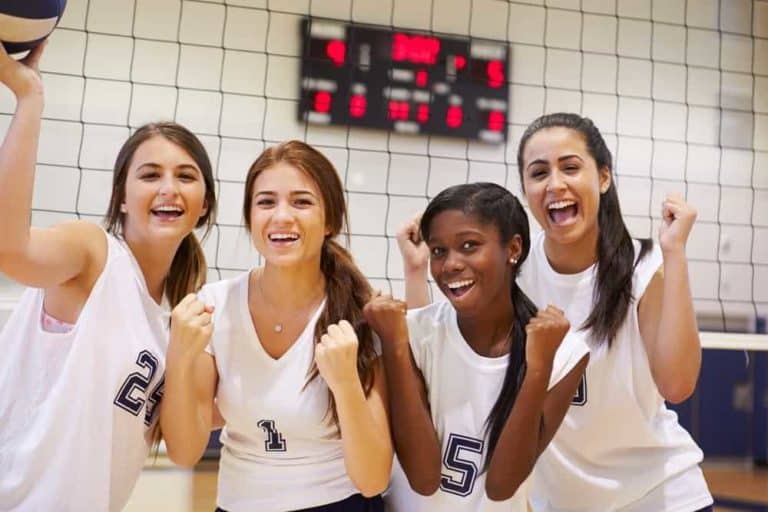 Young women on a volleyball team posing for a photo.