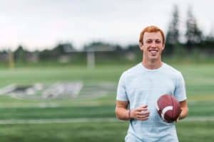 A young athlete with a football on the field.