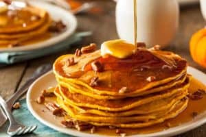 Delicious pancakes with pecans, butter, and syrup.