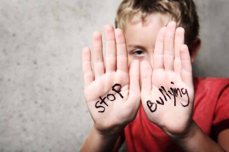 A boy with the phrase stop bullying written on his hands.
