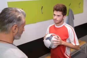A nervous soccer player talking with his coach.