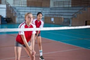 Teenage girls playing volleyball.