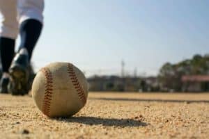 kid playing baseball on a sandlot