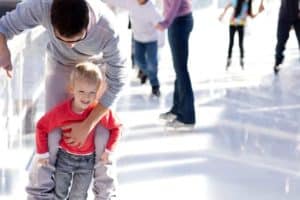 kid ice skating with father