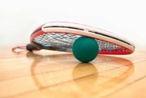 racket and ball on racquetball court