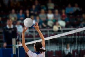 Girl Volleyball player and setter setting the ball for a spiker during a game