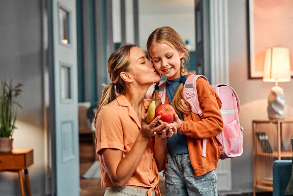 mom giving daughter healthy snacks