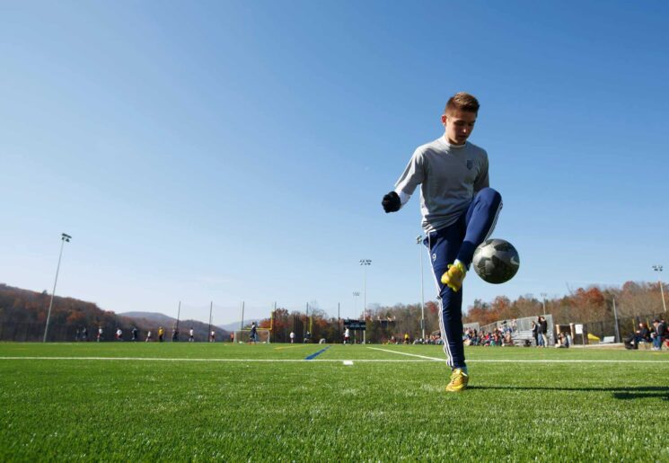 Teen playing soccer outside